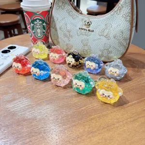 Detailed close-up shot of colorful quicksand glitter tuanzi resin keychains arranged on a wooden table.
