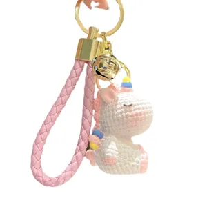 Cute cartoon resin rainbow unicorn keychain bag pendant with pink braided strap and bell.
