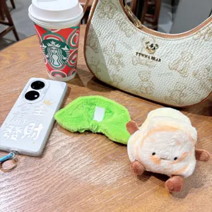 Scene display of cute cartoon plush food toy keychain, soft plush toy resting on wooden table.