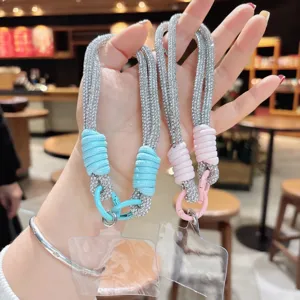 Dettaglio cinturino da polso per telefono con strass scintillanti e design in corda intrecciata.