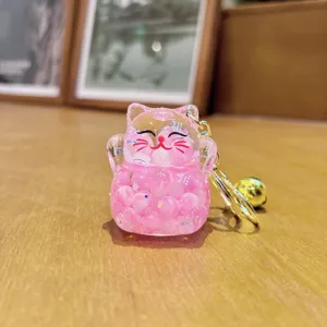 Niedlicher flüssiger rosa Acryl Glückskatze Schlüsselanhänger mit Glitzerperlen und Goldglocke.