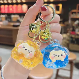 Close-up of cute quicksand keychain pendant with glitter, clear resin design and bells.