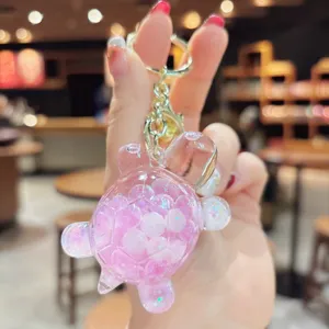 Primo piano dettagliato del simpatico portachiavi a tartaruga liquido con brillantini rosa.
