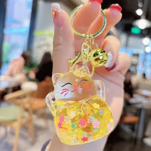 Close-up detail view of the liquid quicksand lucky cat acrylic keychain with sparkly glitter.