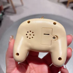 Close-up back view of mini game console keychain showing battery compartment and speaker.