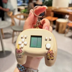 Close-up detail of cute capybara electronic game console keychain with mini screen and buttons.