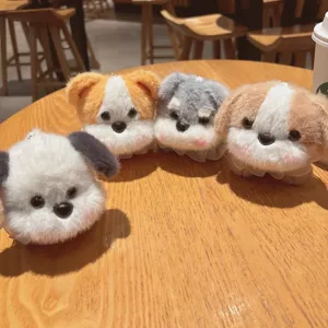 Primo piano di simpatici portachiavi con cagnolini di peluche colorati, perfetti pendenti.