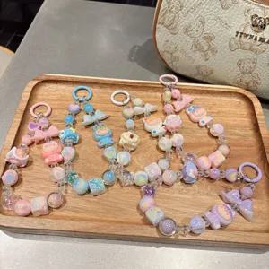 Detailed shot of cute pastel beaded phone charms and keychains with lovely cartoon doll pendants.