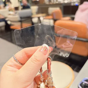 Detalle de parche de sujeción para teléfono transparente con llavero de abalorios.