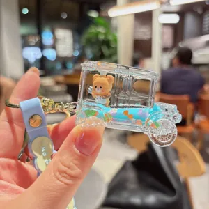 Nahaufnahme des süßen Treibsand Acryl Bär Auto Schlüsselanhänger mit Glitzer.