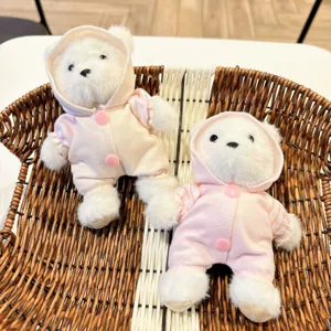 Süßer Plüsch Teddybär Schlüsselanhänger mit rosa Kapuzenanzug im Korb präsentiert.
