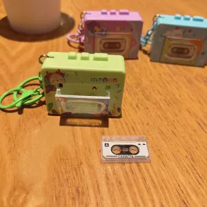 Mini cassette player keychain detail, cute cartoon design, retro music bag charm gift.