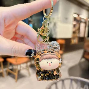 Detailed close-up of the acrylic quicksand keychain featuring a cute doll pendant and shiny glitter.