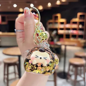 Close-up detail of cute quicksand keychain, featuring sparkling glitter and shiny gold ring.