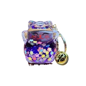Cute purple lucky cat liquid quicksand keychain with glitter flowers and a gold bell pendant.