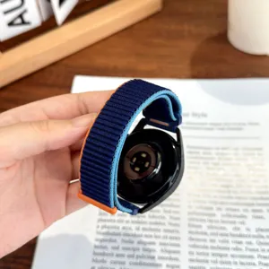 Dettaglio cinturino smartwatch in nylon, design bicolore blu e arancione con connettore in metallo.