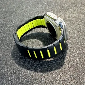 Closeup detail of the black and yellow dual-color curved link watch band showing texture.