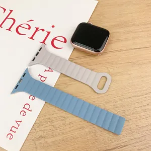 Silikon Magnet Uhrenarmbänder in Grau und Blau präsentiert auf einer sauberen Holztischoberfläche.