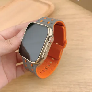 Vista dettagliata del cinturino in silicone bicolore con fori traspiranti in grigio e arancione.