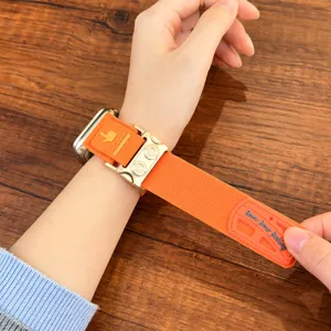 Dettaglio cinturino orologio tattico in nylon arancione, fibbia metallo armatura polso.