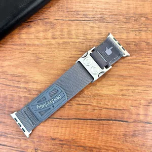 Dettaglio cinturino per orologio in nylon grigio con fibbia meccanica e stemma in gomma.