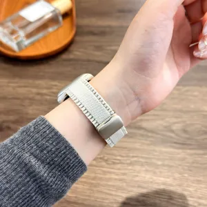 Detailopname van beige gevlochten nylon horlogeband met magnetische gesp gedragen om de pols.