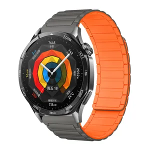 Detailed close-up of smartwatch with vibrant orange and grey magnetic silicone strap.