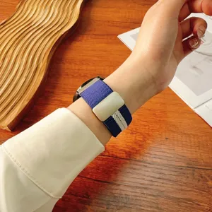 Blue and white striped nylon braided watch strap with magnetic folding clasp, wrist detail.