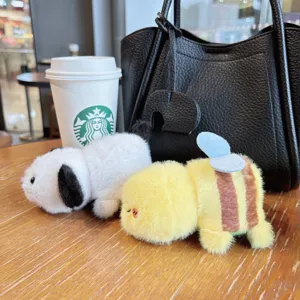 Detailed view of cute reversible capybara and bee plush toy keychain, soft bag pendant.