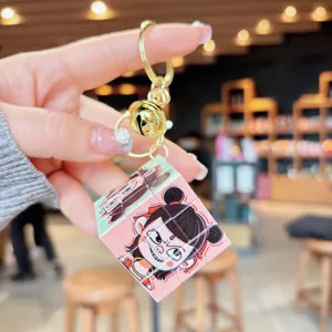 Detailed close-up of cute cartoon Nezha mini Rubik cube keychain pendant with gold ring.