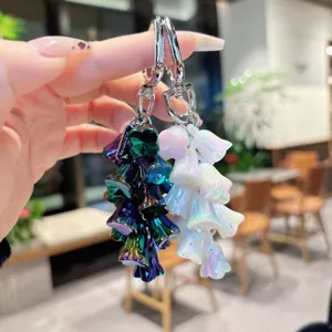 Primo piano dettaglio del portachiavi pendente mughetto colorato con ciondoli floreali iridescenti.