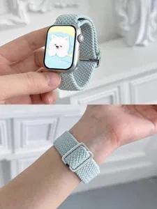 Close-up detail of the mint braided watch strap worn on wrist, showing secure metal buckle.