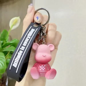 Süßer rosa Harz Bär Schlüsselanhänger mit schwarzem Gurt und Metallring für Schultasche.