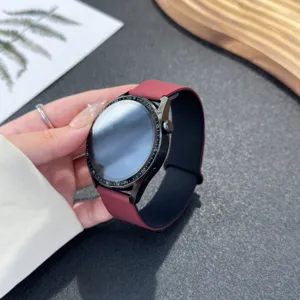 Detailed view of a stylish maroon silicone smart watch strap with a sleek black dial bezel.