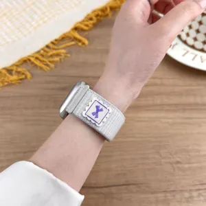 Close-up detail shot of the nylon loop watch band featuring a cute purple bow embroidery.
