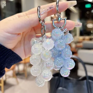 Detailed close-up of colorful iridescent acrylic fruit bag charm and stylish keychain.
