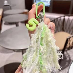 Ciondolo numero 5 verde nappina soffice accessorio borsa, vista dettagliata portachiavi peluche.