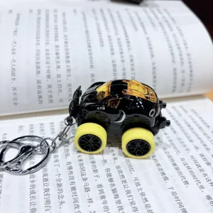 Detail view of the alloy pull-back monster truck keychain with yellow wheels and unique design.