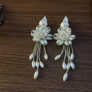 Pearl flower tassel hair clip detail view showing elegant beaded floral design and dangling tassels.
