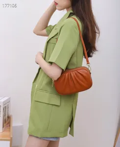 Detailed view of fashionable genuine leather women shoulder bag featuring stylish ruched design.