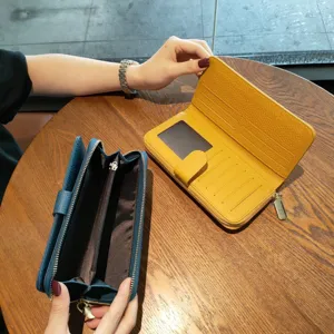 Detailed view of women long genuine leather wallet showing multiple card slots and zipper pocket.