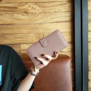 Detailed close-up of a stylish women's long bifold leather clutch wallet in mauve pink.