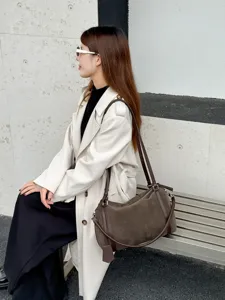 Detail view of the large capacity casual commuting shoulder bag in stylish brown tone.