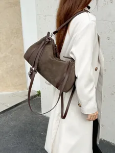 Brown suede shoulder bag detail, stylish commuter handbag with unique side strap design.