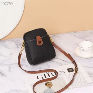 Detailed view of the mini leather crossbody phone bag on a marble tabletop with stylish props.