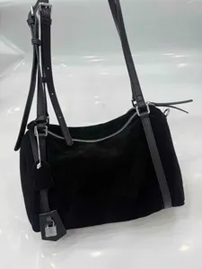 Black suede shoulder bag detail, minimalist casual handbag with padlock charm and zipper.