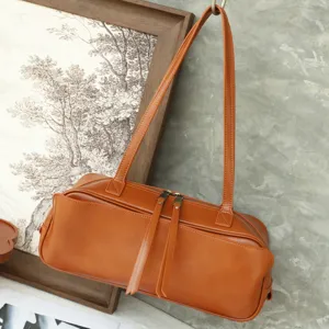 Minimalist vegetable-tanned leather bowling shoulder bag for women, stylish brown Boston handbag.