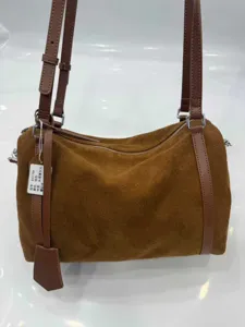 Brown suede shoulder bag detail showcasing premium leather texture and durable dual straps.