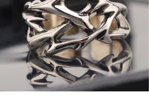 Close-up detail of vintage Thai silver open ring with intricate hollow thorn branch design.