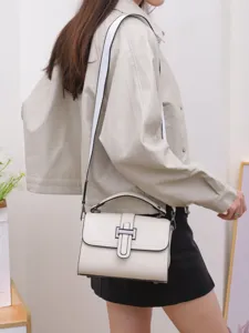 White leather crossbody bag women top handle small square flap bag carried by model